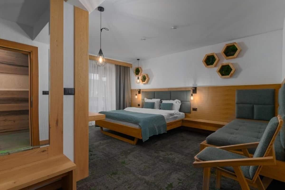 Un dormitorio con cama, una silla, un escritorio y ventana.