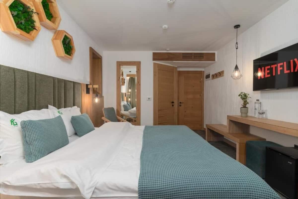 Una habitación de hotel con cama, televisión, escritorio y espejo.