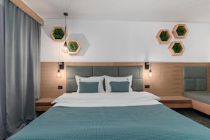 A hotel room with a bed, two bedside tables, a headboard, and hexagonal wall decorations.
