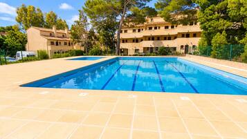 Une piscine à l’eau d’un bleu cristallin, entourée d’une terrasse carrelée.
