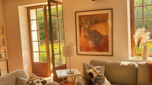 A living room with a sofa, a coffee table, a lamp, and a painting. - La Maison de la Tour (Léré)