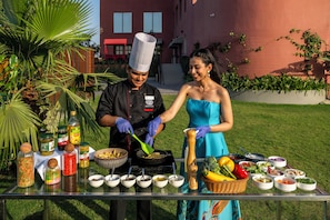 A chef preparing food outdoors with various condiments and ingredients on a table. - Tree of Life Ganga Dwar Haridwar (Haridwar)