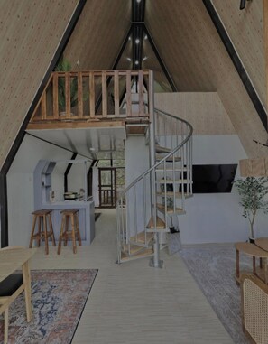 A modern interior with a loft bedroom, a kitchen area, and a staircase.