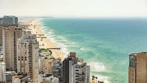 Een kuststadsbeeld met hoge gebouwen, een strand en een helder uitzicht op de oceaan.