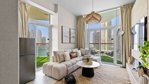 Ein modernes Wohnzimmer mit einer Couch, einem Couchtisch und Blick auf eine Skyline durch große Fenster.