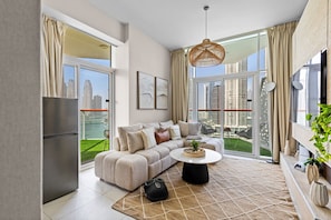 A modern living room with a sofa, coffee table, and a view of a cityscape through large windows.