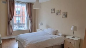 A bedroom with a bed, bedside tables, a window with curtains, and a ceiling light. - Spacious 2 Bed Apartment w/balcony (Dublin 8)