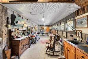 Una cocina rústica con armarios de madera, una mesa de comedor y una mecedora.