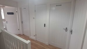 A hallway with white doors, a 'Bathroom' sign, and a 'No smoking' sign. - 3 BEDROOM + LIVING, Terrace House, Sleeps up to 7 people  with Garden (Cardiff)
