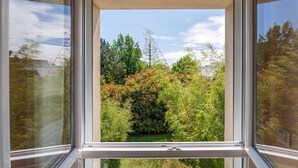 A window with a view of a garden and trees. - Guest Room “Boked Goué” with Shared Terrace & Garden, Wi-Fi (Locoal-Mendon)