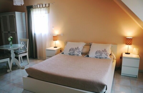 Una camera da letto con un letto, comodini, una sedia, una scrivania e un armadio.