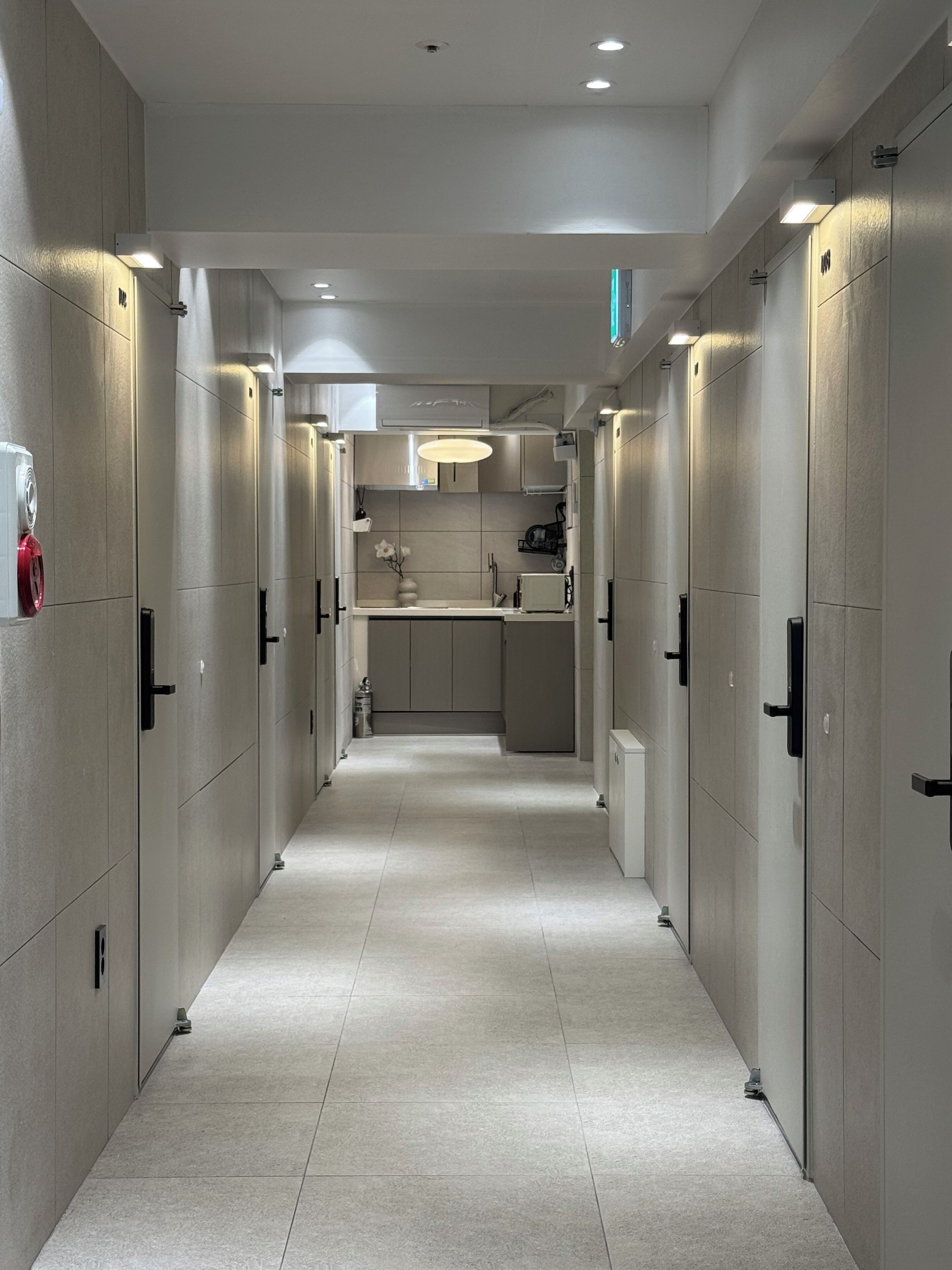 A corridor with lockers, a sink, and a microwave.