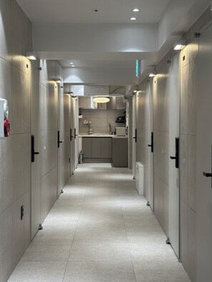 A corridor with lockers, a sink, and a microwave.
