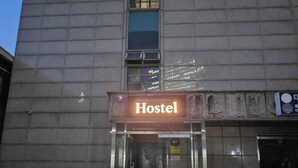 A hostel with a signboard, a metal staircase, and a door. - The dongdaemun hostel (Seoul)