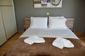 Ein Hotelzimmer mit einem Bett, zwei Kissen, einer braunen Decke und zwei Handtüchern.