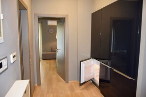 Eine moderne Küche mit Kühlschrank, einem Essbereich und einem Flur, der zum Schlafzimmer führt.