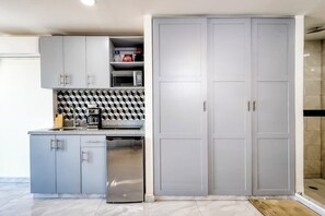 Eine moderne Küche mit grauen Schränken, einer Mikrowelle und einer Kaffeemaschine.