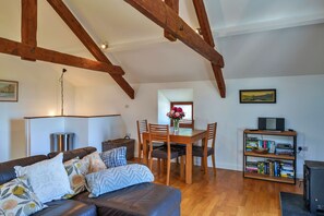 Un salon chaleureux avec un canapé en cuir, une table à manger en bois et des étagères à livres.
