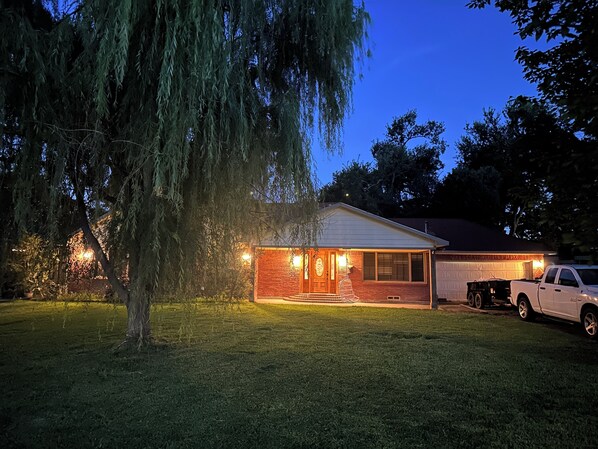 A house with a garage, a driveway, and a tree in the foreground.