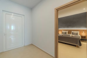 Une chambre d’hôtel avec un lit, des tables de chevet et une porte.
