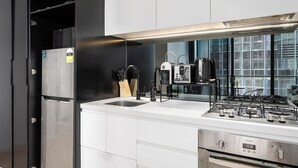 Eine moderne Küche mit Einbaukühlschrank, Kaffeemaschine und Gasherd.