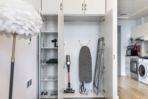 A compact kitchen with a washing machine, a microwave, and a coffee maker.
