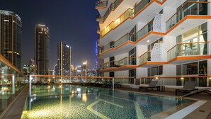 A swimming pool with a cityscape view, modern architecture, and a glass railing. - Gogoto6 Premium Studio Burj Khalifa & Canal View (Dubai)