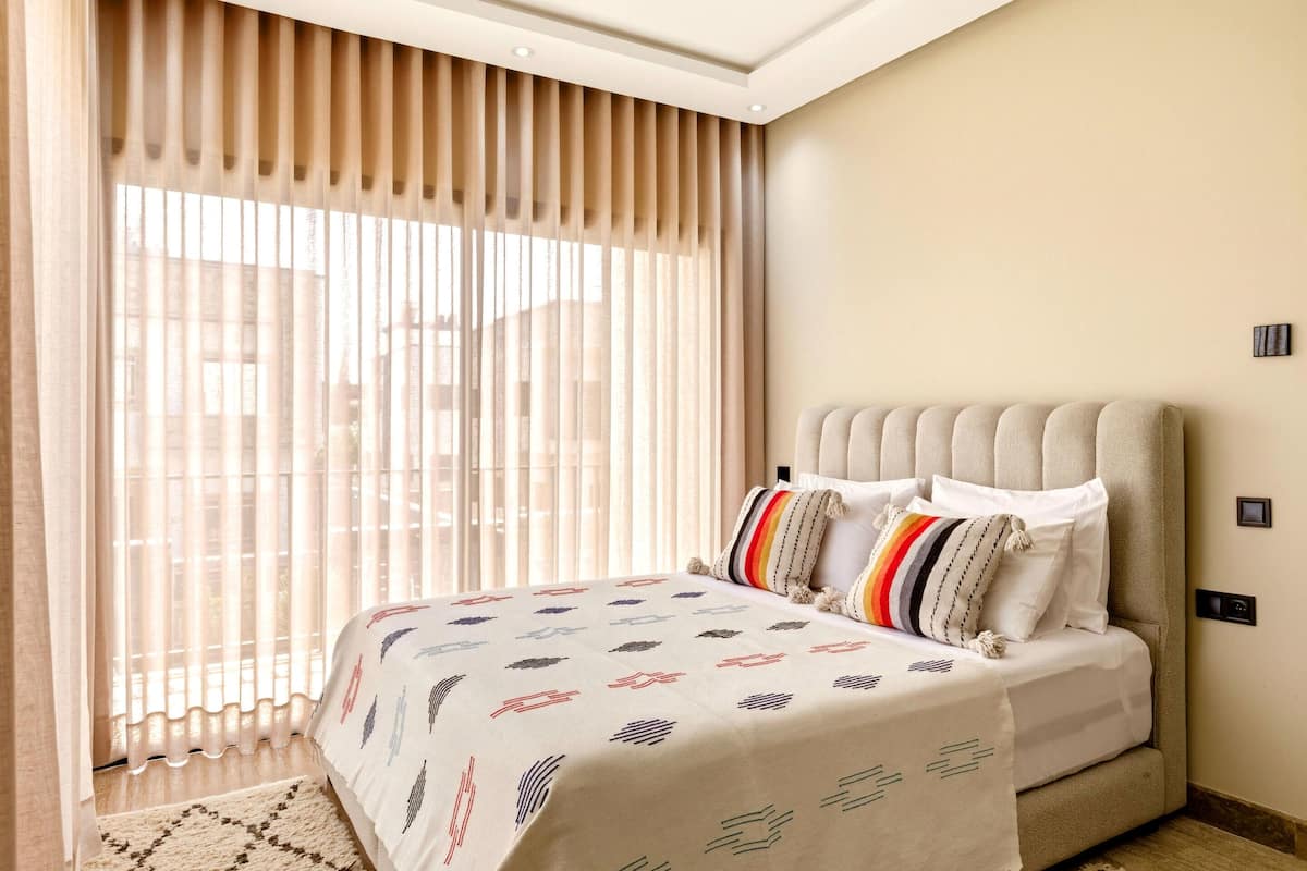 Un dormitorio con cama, cortinas y ventana.