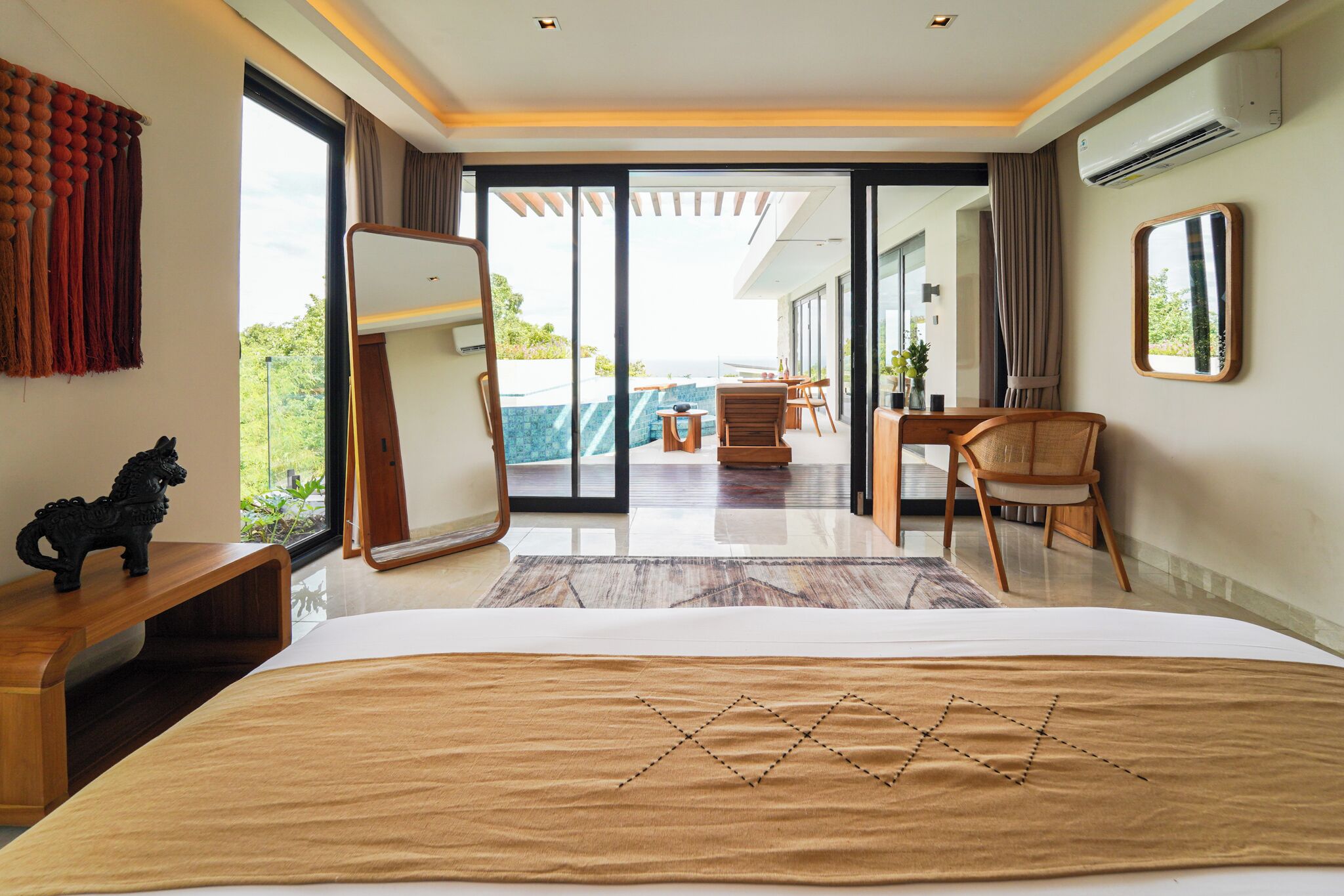 A modern hotel room with a large bed, a desk, a chair, and a view of the outdoors.