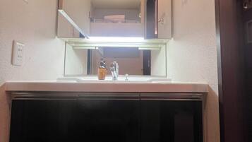 A bathroom with a mirror, sink, and a towel rack.