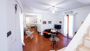 Ein Wohnzimmer mit Sofa, Fernseher und Treppe.