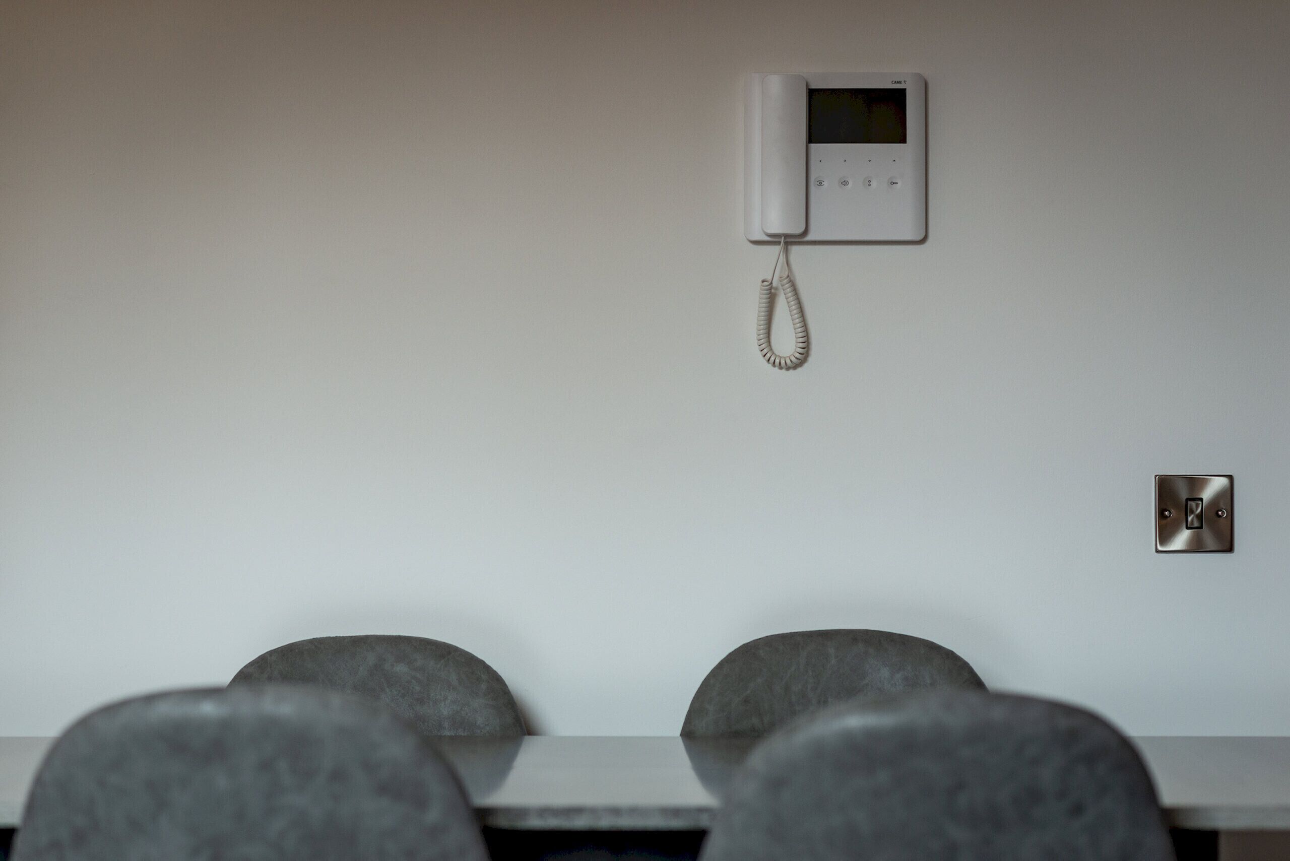Een vergaderruimte met een whiteboard, een telefoon en een stopcontact.