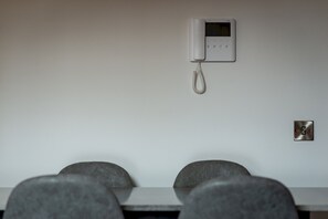 Een vergaderruimte met een whiteboard, een telefoon en een stopcontact.