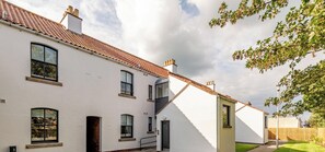 A white building with multiple windows and a sloped roof. - Marine Place | Flat 11 (St Andrews)