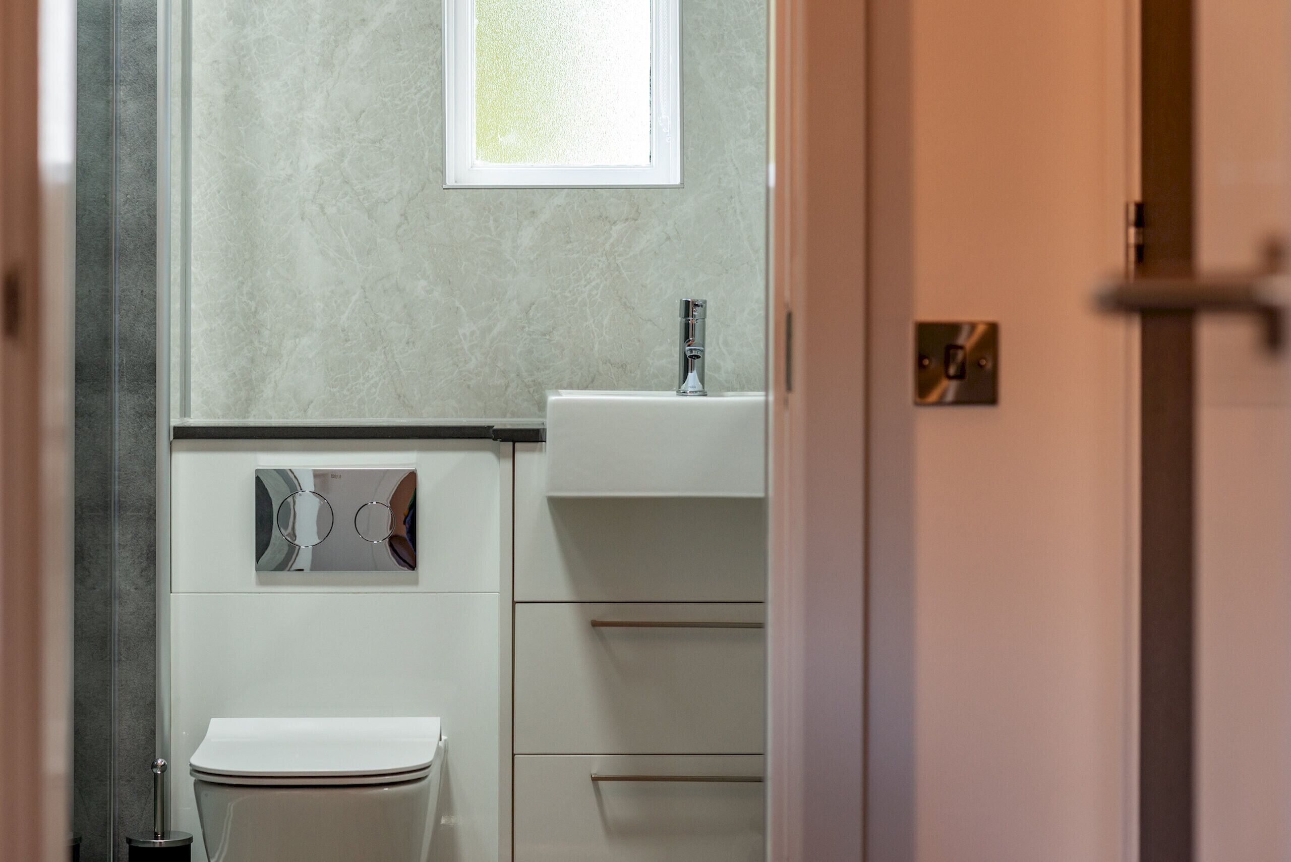 A bathroom with a toilet, a sink, and a mirror.