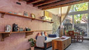 Una habitación acogedora con una cama, una mesa de centro de madera y estantes con diversos objetos.