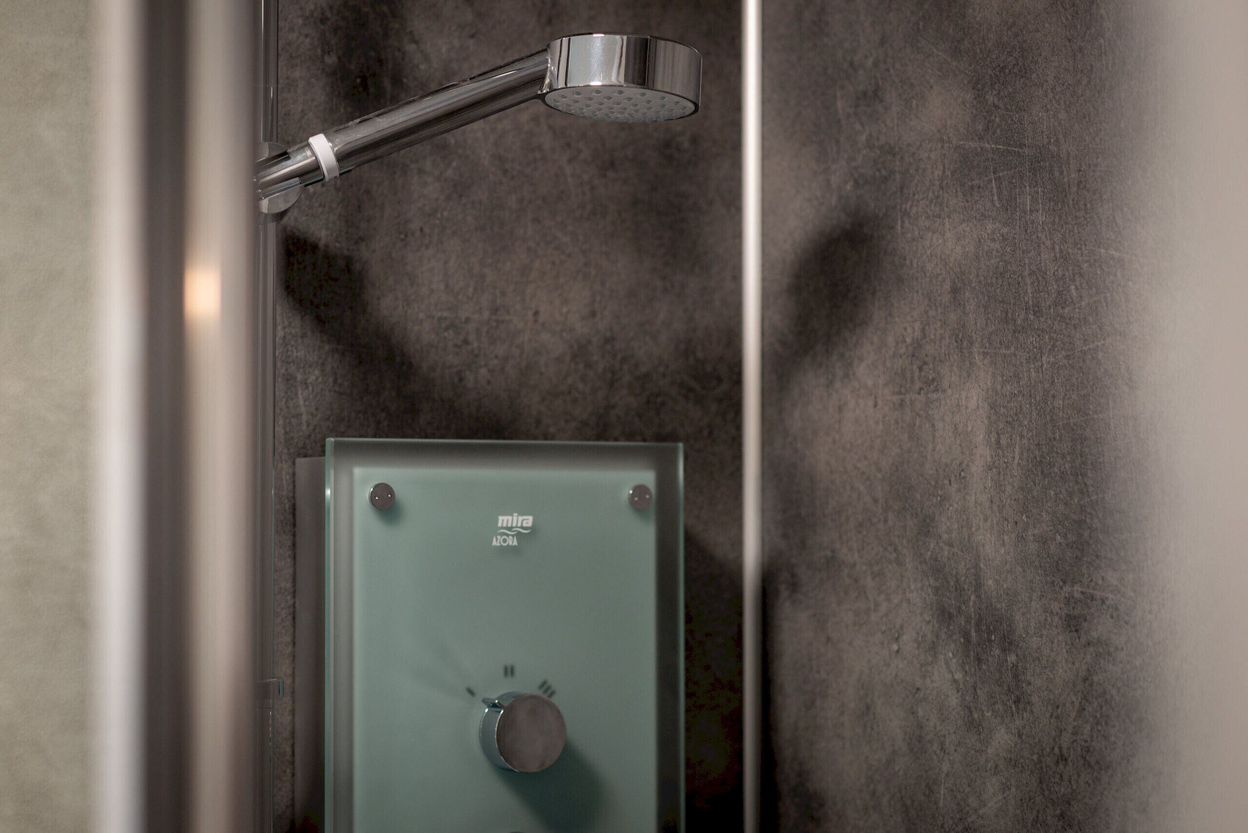 A shower with a control panel labeled 'mira' and a metallic showerhead.