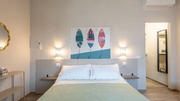 A hotel room with a bed, bedside tables, a wall-mounted artwork, and a mirror.