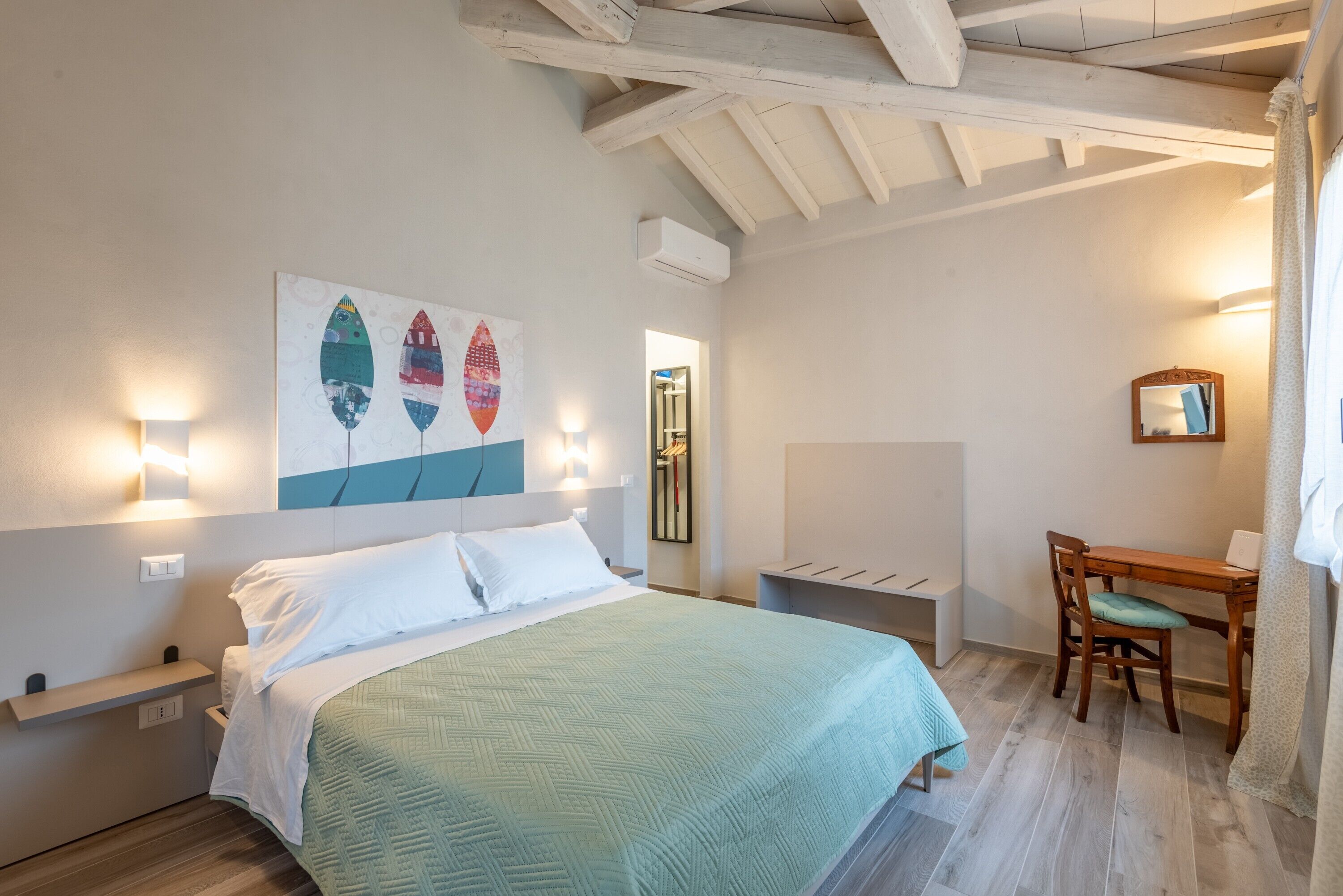 A bedroom with a bed, a desk, and a chair.