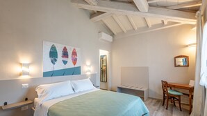 Un dormitorio con una cama, un escritorio y una silla.