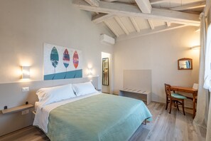 A bedroom with a bed, a desk, and a chair.