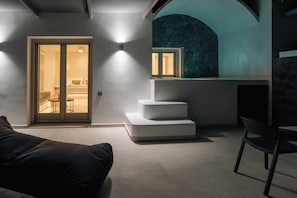 A modern interior with a staircase, a sofa, and a dining area.