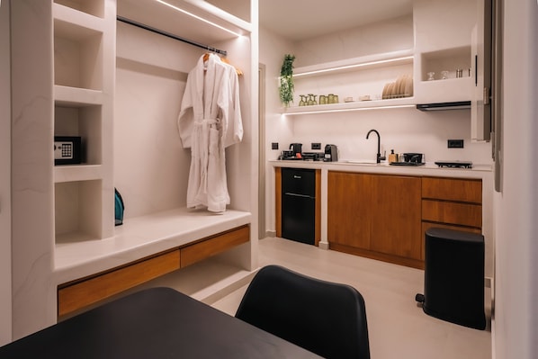 A modern kitchen with built-in appliances, wooden cabinets, and a black trash bin.
