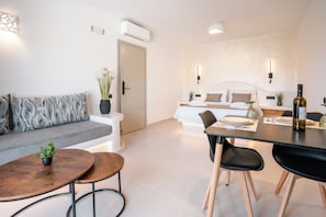 A modern living room with a sofa, coffee table, and dining area.