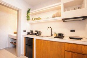 Een moderne keuken met een ingebouwde vaatwasser, houten kastjes, een roestvrijstalen spoelbak en een afzuigkap.