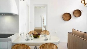 Een moderne keuken met een eethoek, witte muren en een plafond met zichtbare balken.