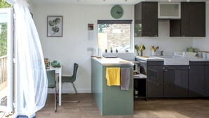 Una cocina moderna con comedor, una pequeña isla y vistas al exterior.