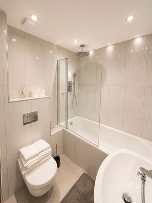 Ein modernes Badezimmer mit einer Duschkabine, einer freistehenden Badewanne und einem WC.