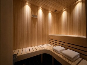 A sauna with wooden slats, a bench, and towels.