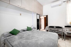 Une chambre Ă coucher avec un lit, un bureau et une chaise.